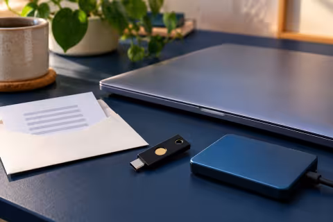 A security key, locked laptop, recovery-code envelope and separate backup drive.